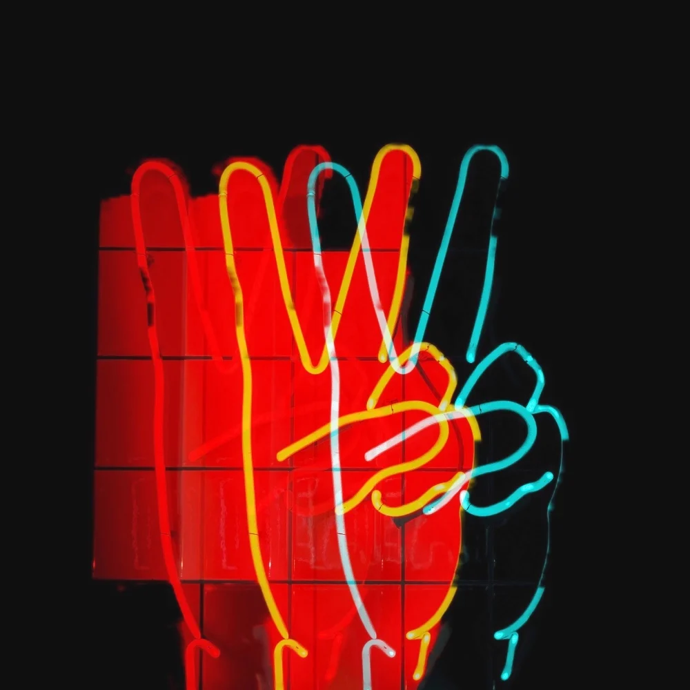 Ihre Vorteile sind unsere Leistungen im Affiliate-Marketing Bild: Neonlicht von drei Händen, die das Victory-Zeichen zeigen.